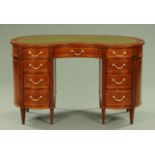 An Edwardian inlaid mahogany kidney shaped desk, with green tooled leather writing surface,