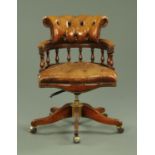 A mahogany leather upholstered revolving desk chair,