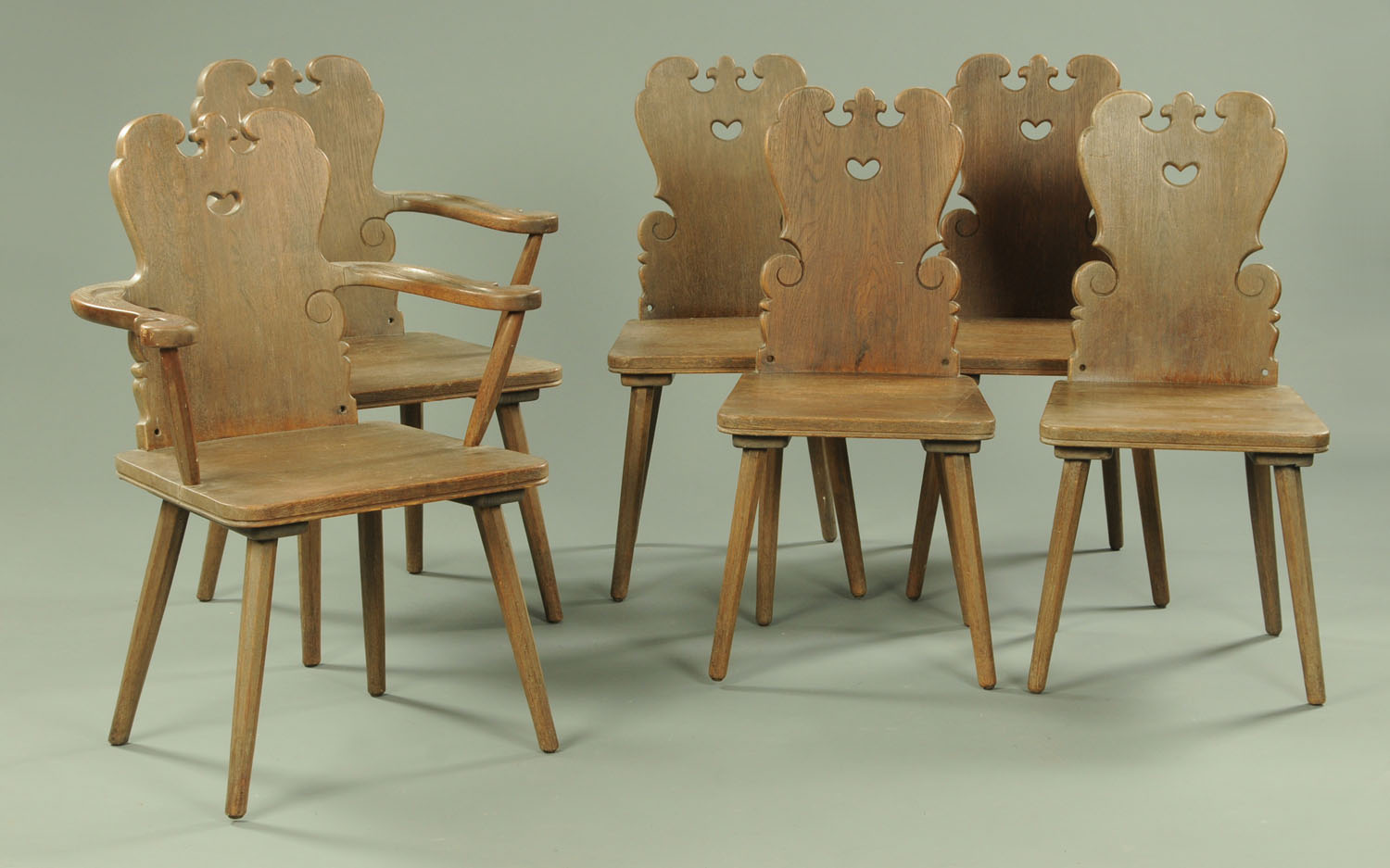 A set of two carver arm and four single oak dining chairs,
