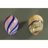 A polished hardstone egg, and Nailsea glass egg. Each +/- 6 cm.