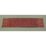 An Eastern fringed runner, with centre rectangular panel and three line border, 250 cm x 60 cm.