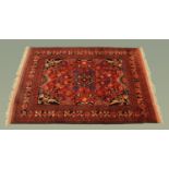 A large Persian design woollen fringed rug, with centre rectangular panel decorated with vases,