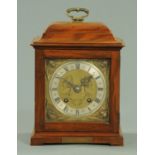 An early 20th century walnut bracket clock, having a square brass dial with silvered chapter ring,