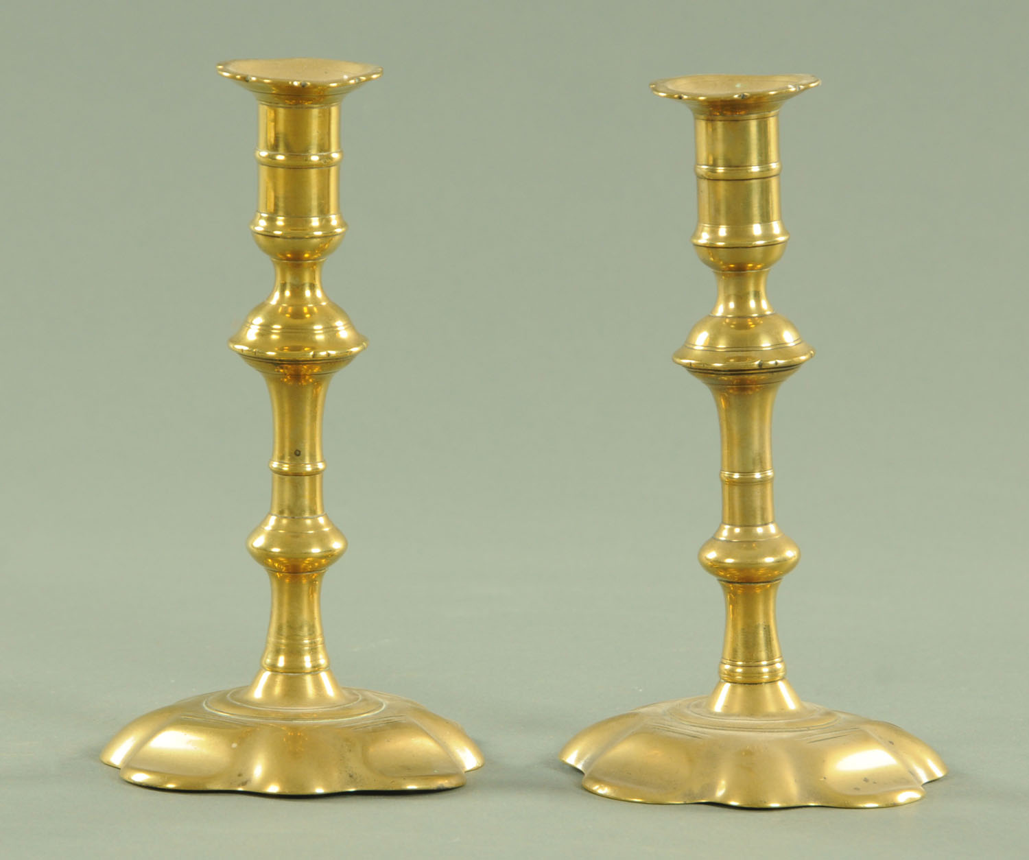 A pair of 18th century petal shaped candlesticks, with petal shaped sconces and knopped stem,