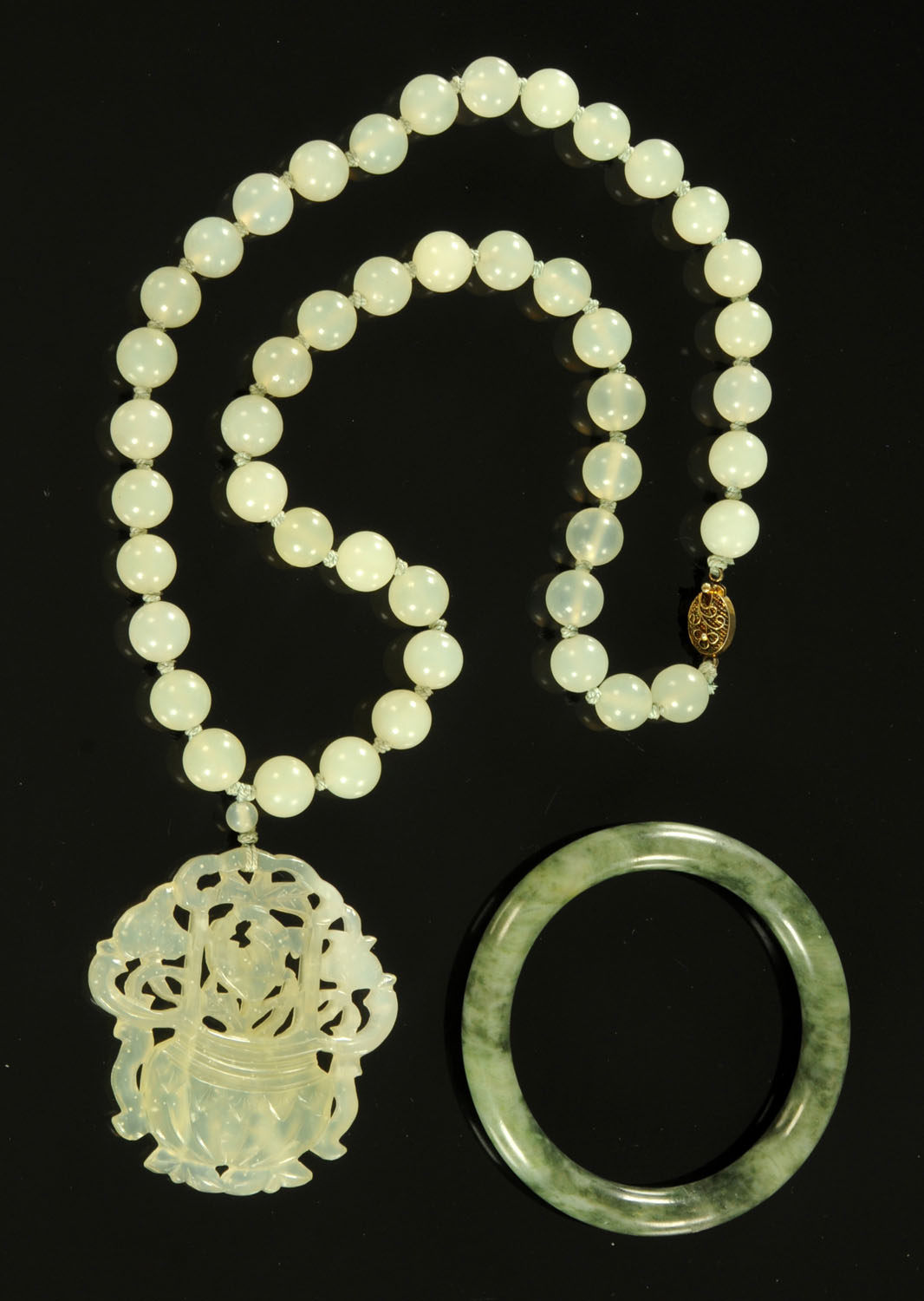 A Chinese jade pendant on beaded necklace, 20th century, with silver gilt clasp,