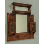 A late Victorian walnut framed overmantle mirror, with mirrors, shelves and cupboards.