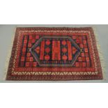 An Eastern fringed rug, principle colours black,