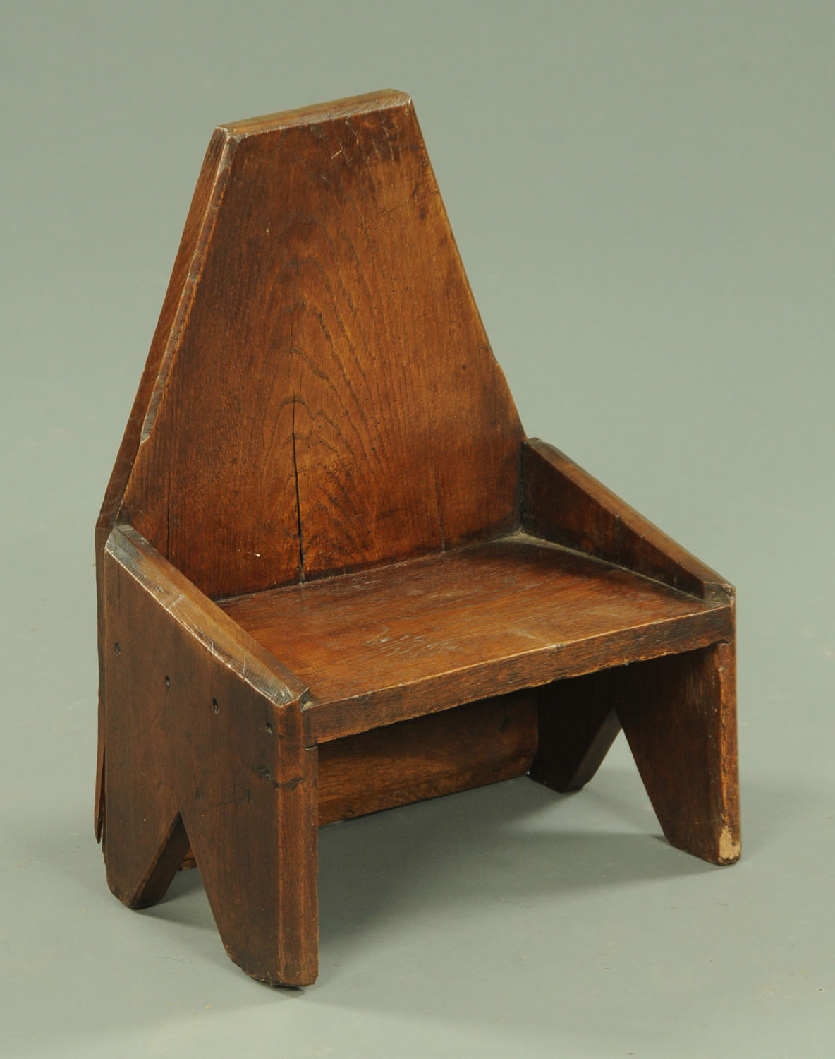 A 19th century small oak stool, of angled form and silhouette sides, width 34.5 cm.