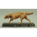 A spelter figure of a prowling setter, raised on a marble plinth, length 60 cm, height 28 cm.