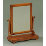 A Victorian mahogany framed toilet mirror, with serpentine base raised on short bun feet.