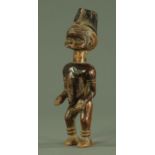 A West African carved wood figure of a man, 20th century, possibly Yoruba,