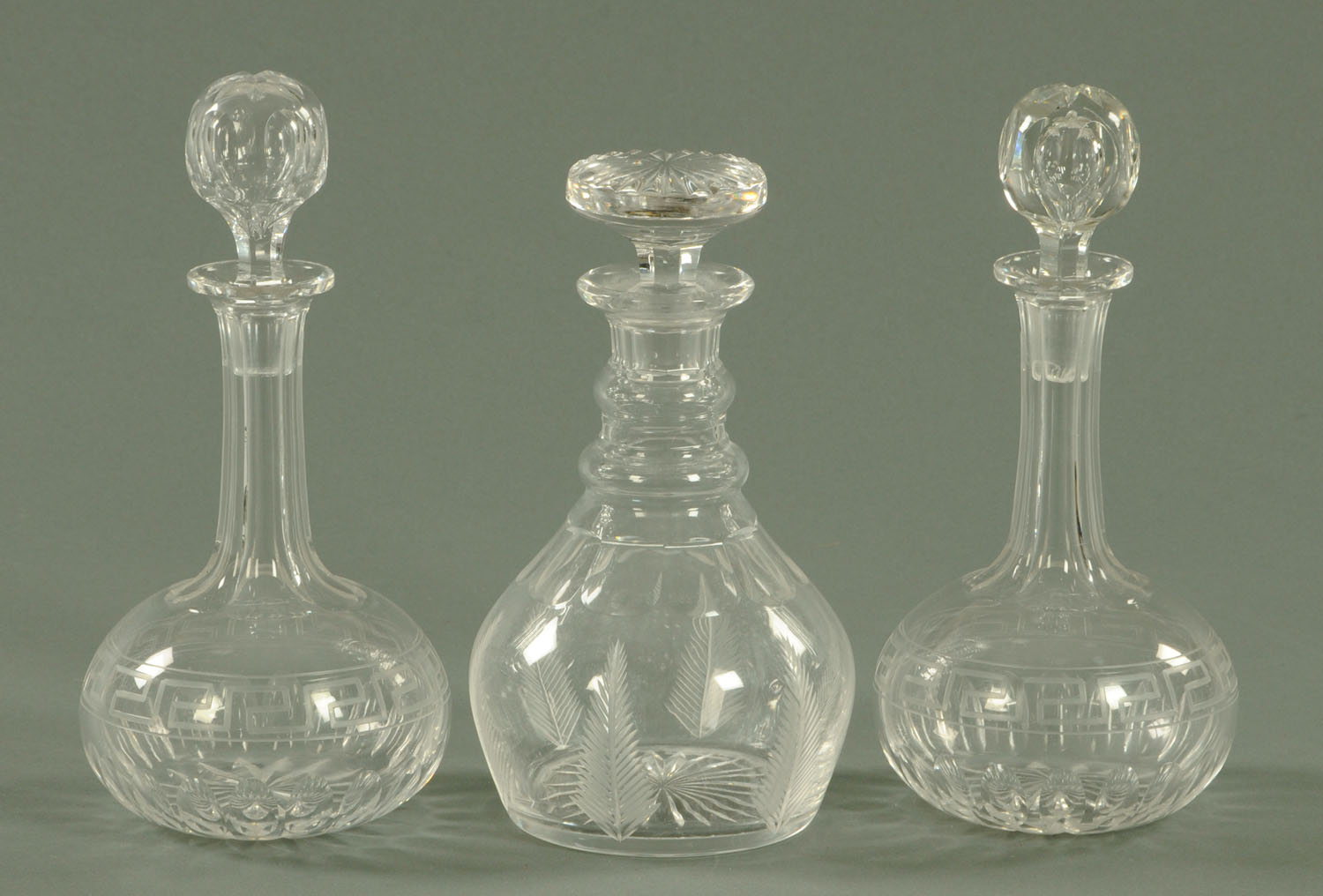 A pair of globe and shaft decanters, late 19th century, with faceted neck above a Greek key band,