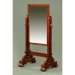 An early Victorian mahogany framed cheval mirror, raised on sledge supports with scroll feet,