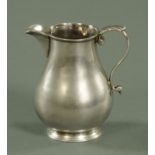 A silver cream jug, makers initials CO with pellet, London, with scroll capped handle, height 10 cm.