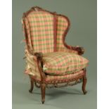 A French carved walnut wing armchair,