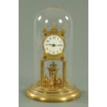 A early 20th century brass anniversary clock, beneath a glass dome and upon a raised circular base,