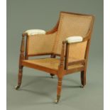 A Regency mahogany bergere armchair, with moulded showframe and upholstered arms,