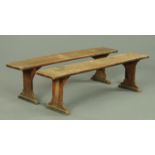 A pair of late Victorian oak benches, each with silhouette supports, length 167 cm.