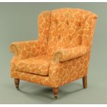 A Victorian style wing armchair, with button back and rollover arms,