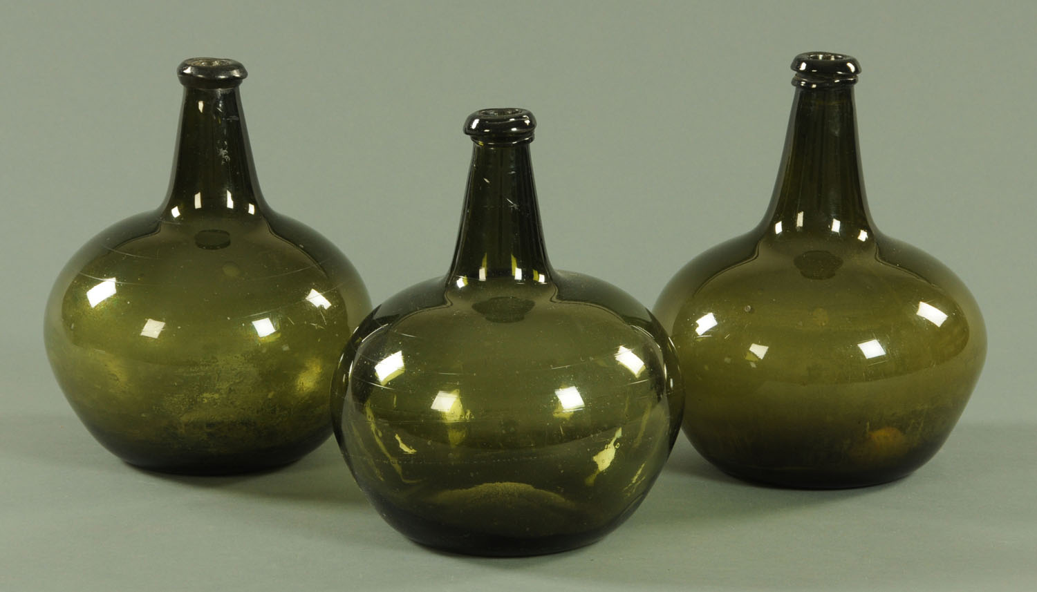 Three 18th century style olive green wine bottles,