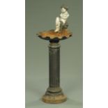 A cast iron birdbath, with putto seated on a shell. Height 94 cm, width across shell 34 cm.