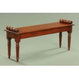 A mahogany window seat, with bolster ends and moulded edge and raised on four turned legs,
