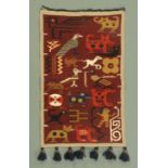A South American woollen wall hanging, decorated with figures, birds and animals, 100 cm x 63 cm.