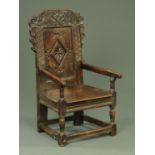 A 17th century Yorkshire oak Wainscot chair, with carved cresting rail and panelled back,