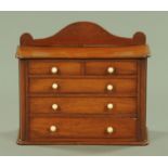 A Victorian mahogany miniature chest of drawers, with rear upstand,