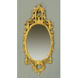 A Chippendale style giltwood framed oval mirror. Height 143 cm, width 64 cm (see illustration).