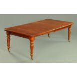 A Victorian mahogany extending dining table, with two leaves, wind out action,