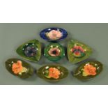 Seven Moorcroft ashtrays, mid 20th century, in orchid, magnolia and hibiscus patterns,