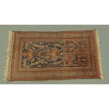 An Eastern prayer rug, principal colours blue and beige, with fringed ends. 135 cm x 78 cm.