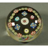 A Baccarat style paperweight, with three canes, with goat, stag and dog, framed by floral canes.