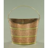 A copper brass bound oval bucket with loop handle. Width 37 cm.
