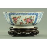 A Chinese Famille Rose bowl, circa 1780, with panels of floral sprays within blue floral borders,