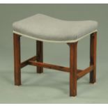 A George III mahogany stool, with bowed seat and raised on moulded legs united by stretchers.