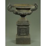 A cast iron black painted garden urn on pedestal. Height 94 cm, width including handles 83 cm.