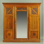 A late 19th/early 20th century walnut wardrobe, in the Arts & Crafts style,