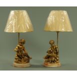 A pair of gilt metal seated cherub table lamps,