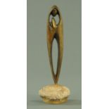 A Modernist bronze figure of The Virgin Mary standing in prayer, mounted on a natural boulder,