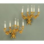 A pair of gilt metal five branch wall light sconces, foliate and with ribbon and bow to the base.