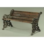 A Victorian style cast iron garden bench, with wooden slats and scroll ends. Width 124 cm.