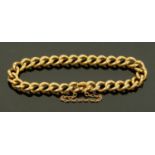 A gold coloured metal link bracelet with safety chain, gross weight 33 grams.