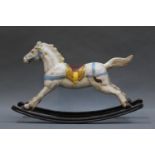 An early 20th century cast iron rocking horse ornament or door stop, having blue coloured bridal,