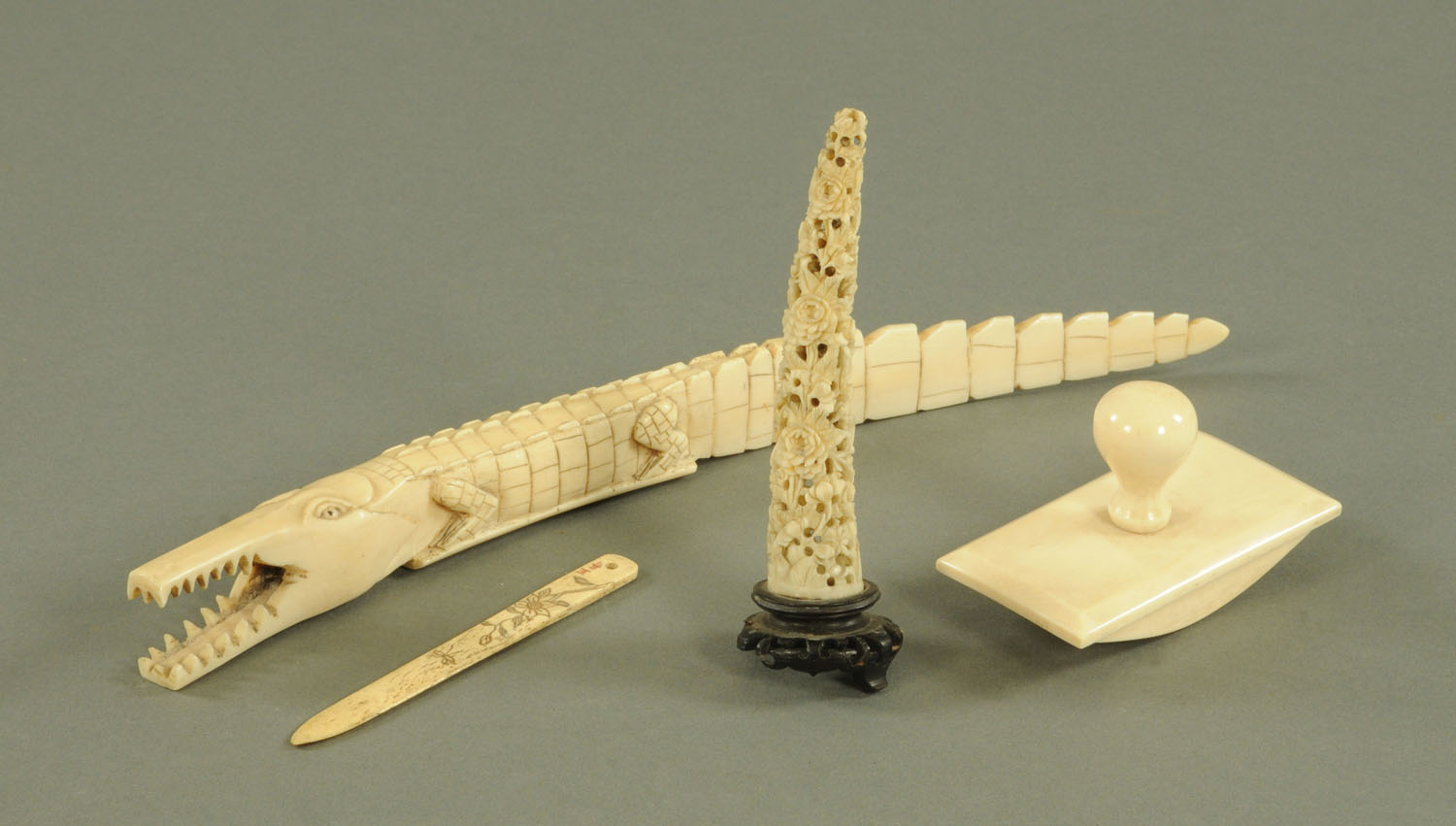 A Japanese carved bone hairpin, Meiji period, decorated with a flower and insect,