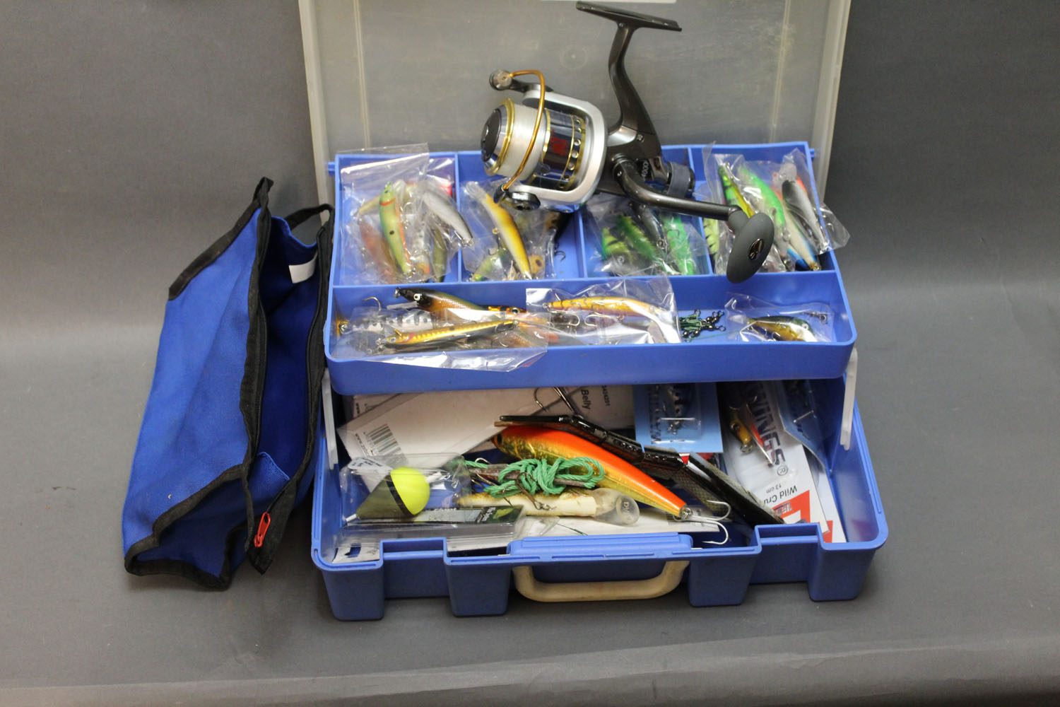 A tackle box filled with lures, pike fishing equipment etc ...