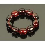A cherry amber bracelet of barrel shaped beads, each bead +/- 2.3-2.4 cm long, 75.5 grams.