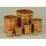 A graduating set of Indian brass and copper grain measures, each inscribed with measurement.
