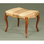 A Victorian walnut stool, of shaped outline, with stuffover top and raised on four cabriole legs.